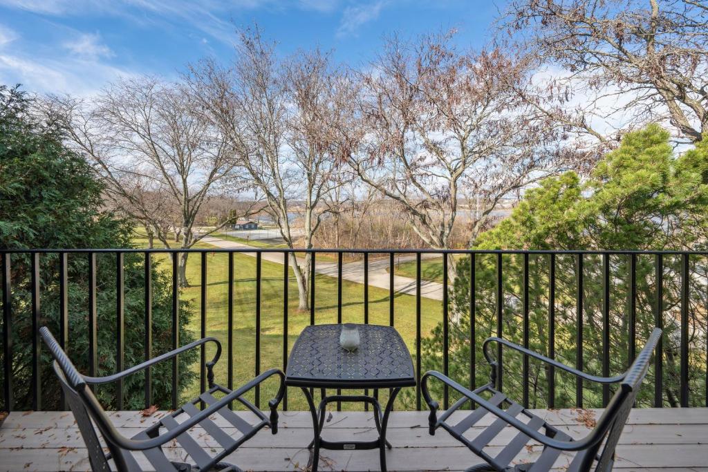 a table and chairs on a balcony with a fence at Elegant 4-Season Lake Geneva Condo with Fireplace! in Lake Geneva