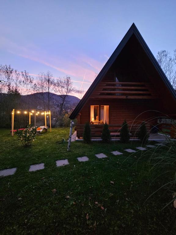 una cabaña de madera en un campo junto a una casa en Nadiaa Wood House, en Ilidža