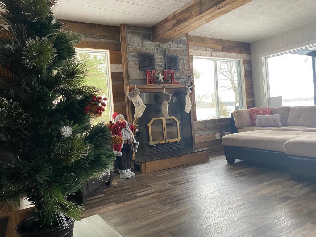 een woonkamer met een kerstboom en een bank bij Chalet Le Shack O2 in Stratford