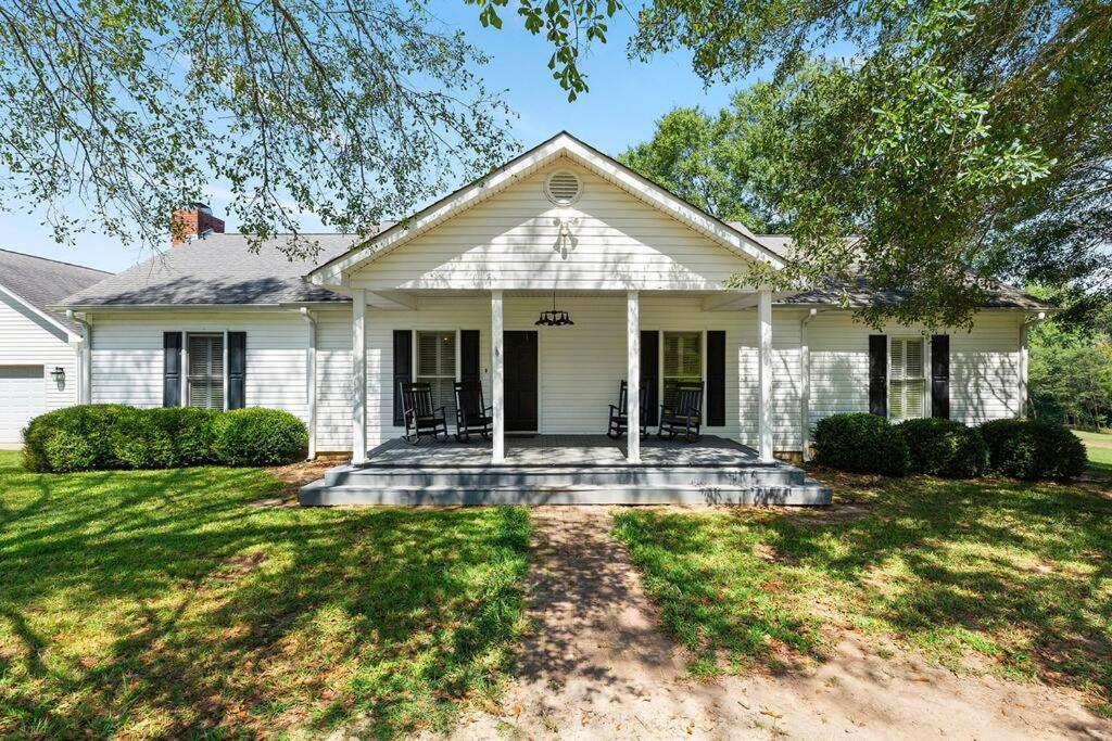 a white house with a porch and a yard at Three Silos Farm -Chatt Hills (NEW & Pet Friendly) in Chattahoochee Hills