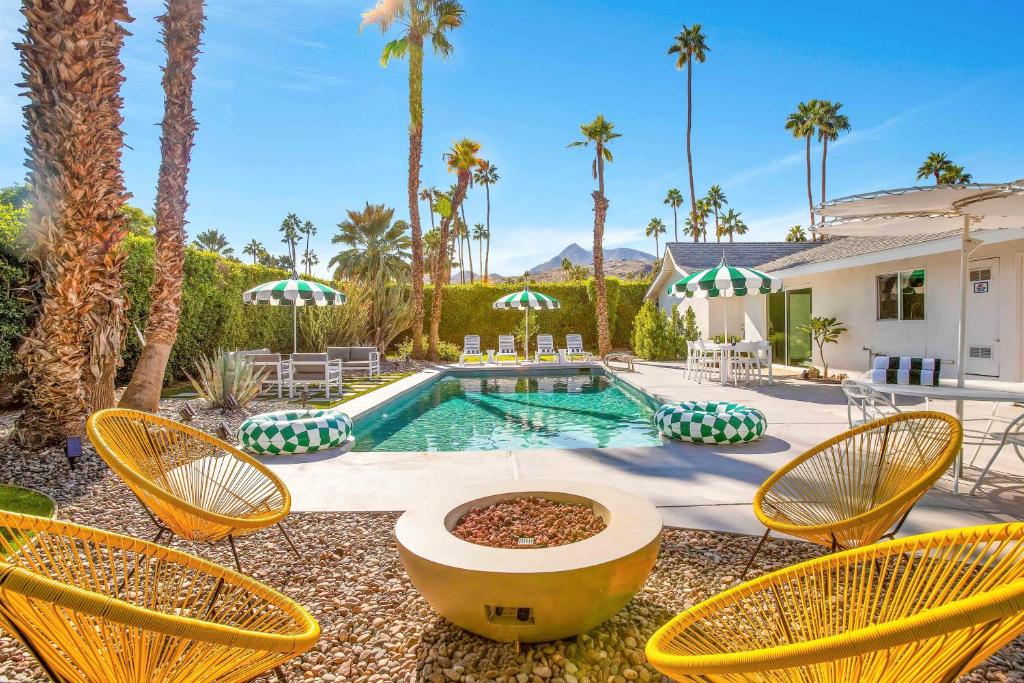 a backyard with chairs and a pool and a house at The Dexter Palm Springs- 1480 in Palm Springs
