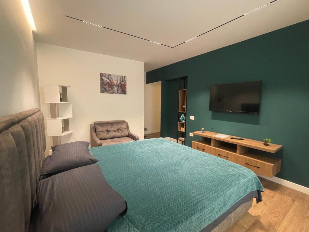 a bedroom with a bed and a flat screen tv at Downtown Studio Apartments in Tirana