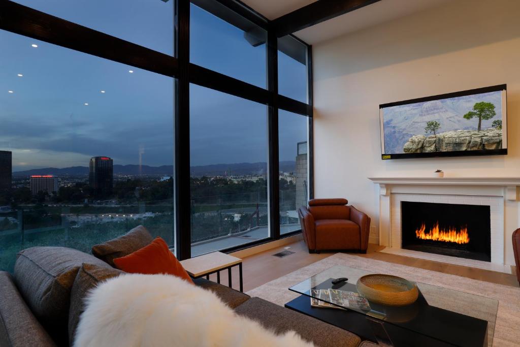 a living room with a couch and a fireplace at Luxury Hollywood Hills Gated VIEW estate - ultra private and gorgeous! MINUTES TO UNIVERSAL STUDIOS AND HOLLYWOOD! in Los Angeles
