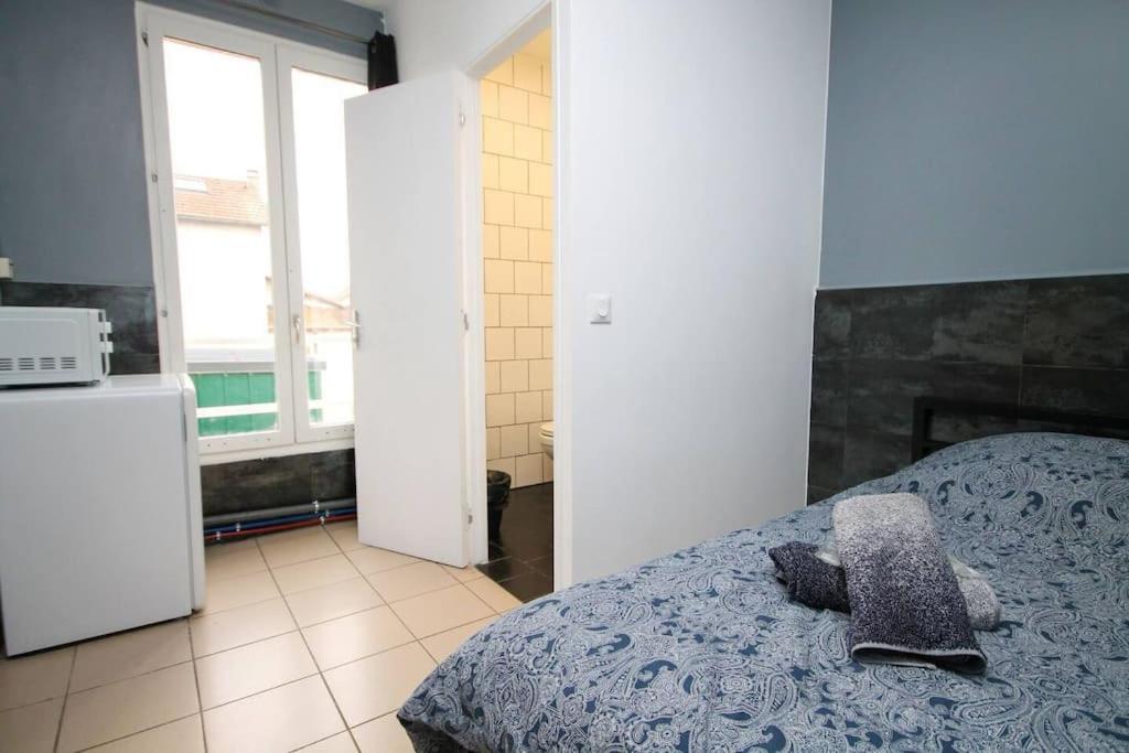 une chambre avec un lit avec un oreiller dessus dans l'établissement 01 - Chambre avec lit double idéal JO 2024, à Saint-Denis