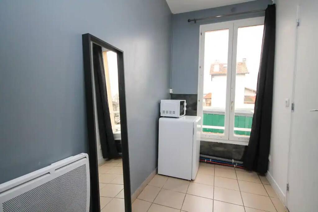 a room with a refrigerator and a window at Chambre avec lit double idéal JO 2024 in Saint-Denis