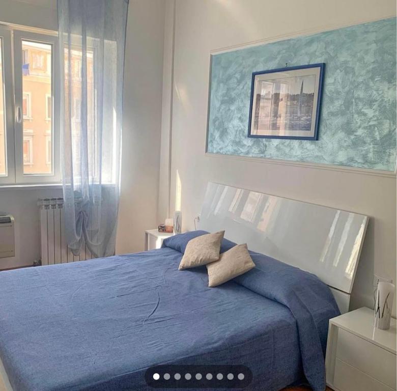 Un dormitorio con una cama azul y una ventana en SoleMare Rooms Trieste en Trieste