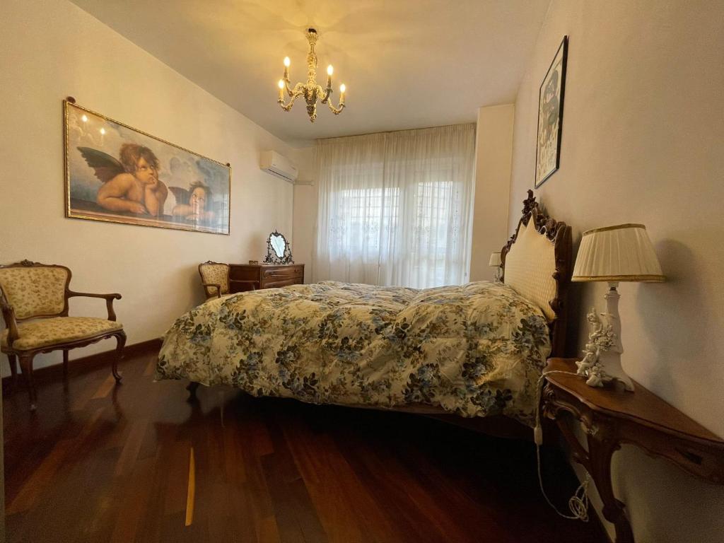 1 dormitorio con cama, lámpara y silla en Stanza classica Eur Tintoretto, en Roma