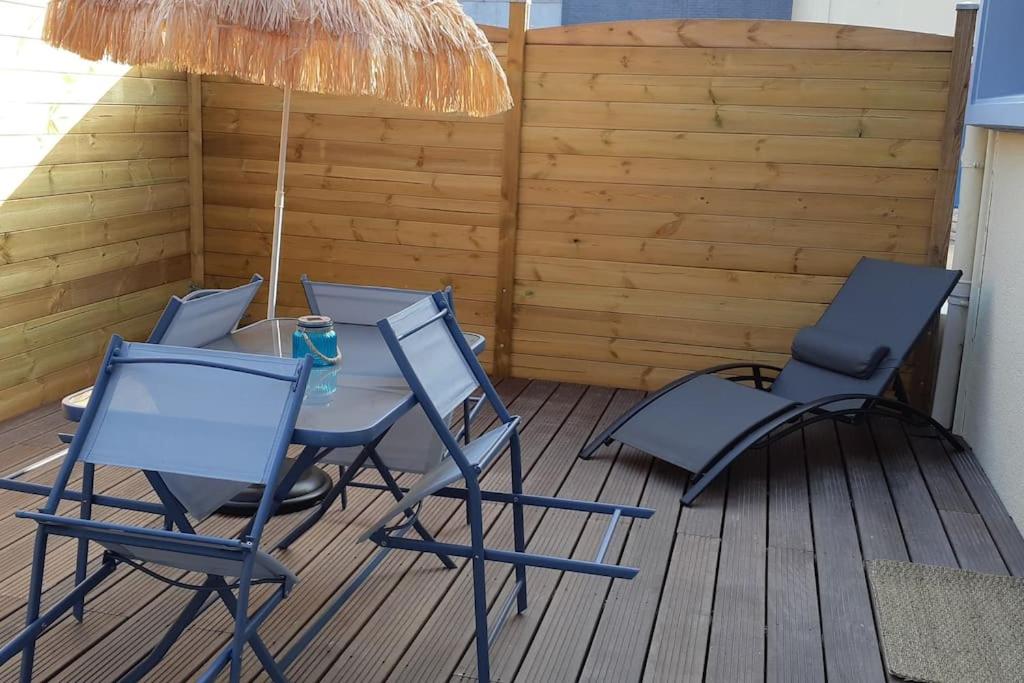 une terrasse avec 4 chaises, une table et un parasol dans l'établissement 