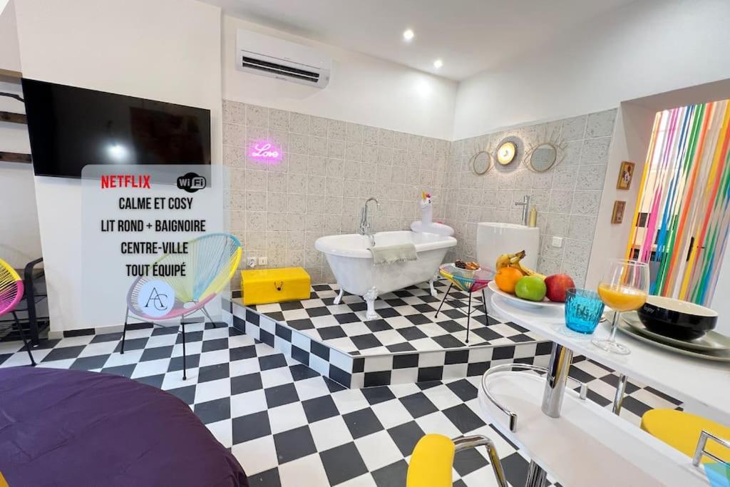 La salle de bains est pourvue d'un sol en damier noir et blanc. dans l'établissement La Suite PopArt - Baignoire - Lit Rond, à Marseille