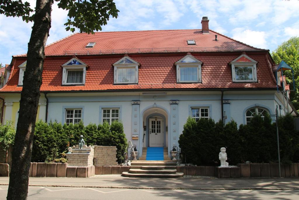 ein großes weißes Haus mit rotem Dach in der Unterkunft LebensART in Bad Dürrheim