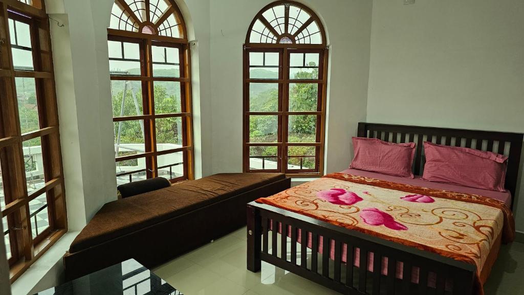 a bedroom with a bed and a couch and windows at The Star Resorts in Vagamon