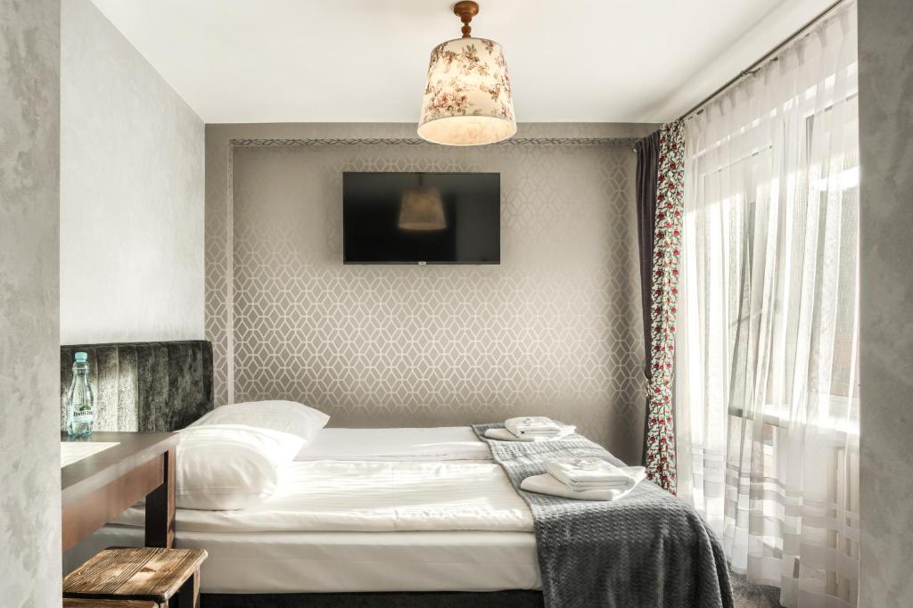 niewielka sypialnia z łóżkiem i oknem w obiekcie Willa Biały Domek w Zakopanem