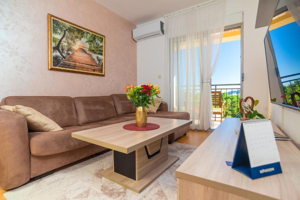 a living room with a couch and a table at Apart hotel M S KATUNJANIN in Herceg-Novi