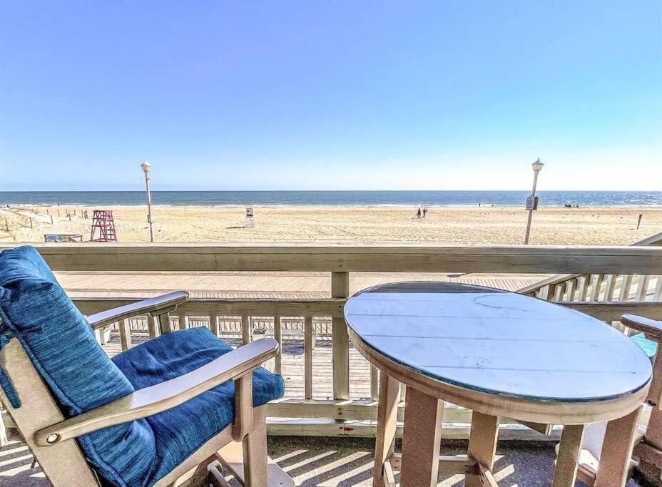 a table and chairs on a deck with the beach at Ocean front * Boardwalk * Private Balcony in Ocean City
