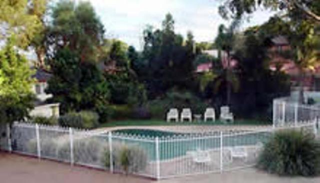 a swimming pool with chairs behind a fence at Lake Haven Motor Inn in Gorokan