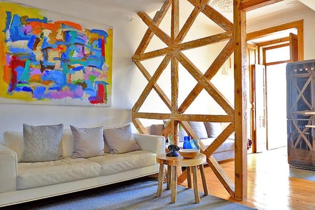 una sala de estar con un sofá blanco y una pintura en PEN-ARTS apartment- PRINCIPE REAL garden - BAIRRO ALTO, en Lisboa