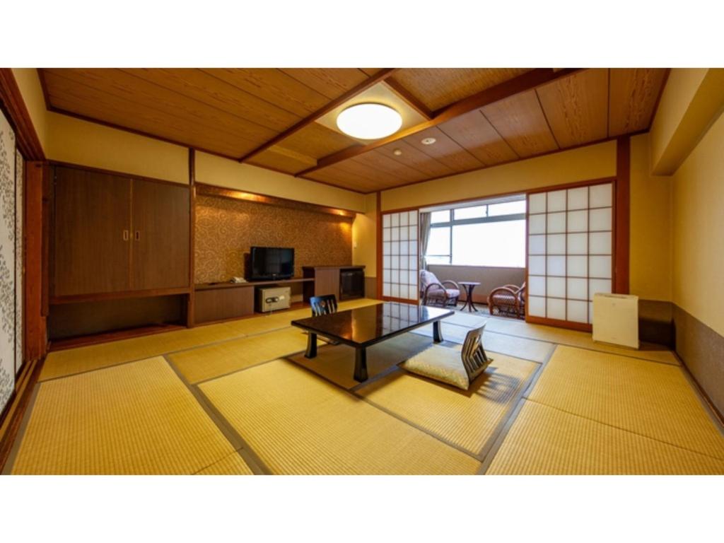 ein Wohnzimmer mit einem Tisch im Zimmer in der Unterkunft Hotel Kimura - Vacation STAY 97364v in Shibukawa