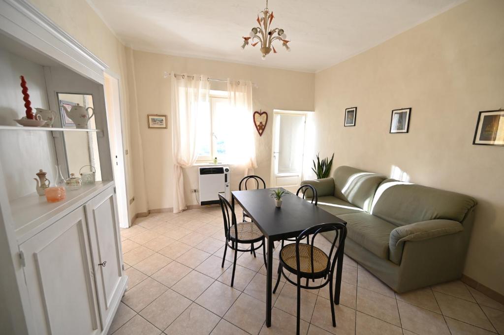 uma sala de estar com um sofá, uma mesa e cadeiras em CASA LETIZIA em Ozzano Monferrato
