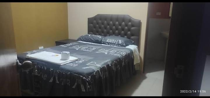 un letto in una stanza con una coperta sopra di HOSTAL LLAUT * * a Moquegua