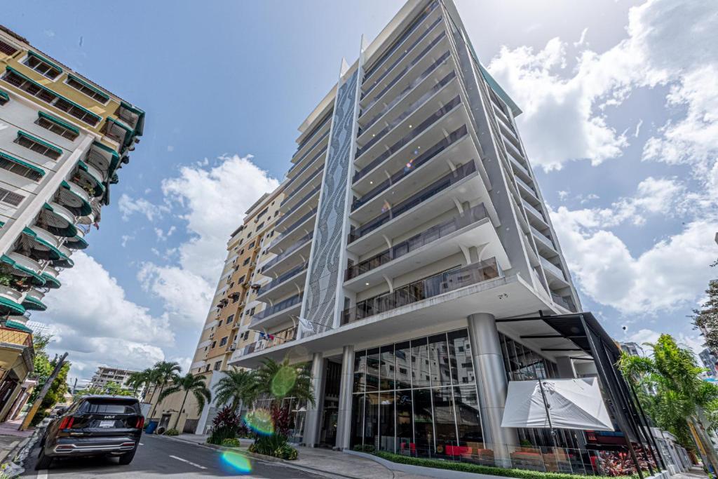 ein hohes Gebäude mit einem davor geparkt in der Unterkunft Brickell Apart Hotel in Santo Domingo