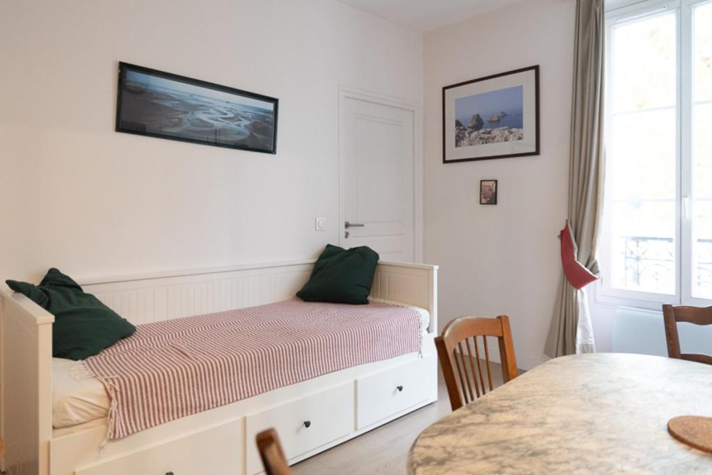 une chambre blanche avec un lit et une table dans l'établissement Bright apartment close to the Seine river, à Boulogne-Billancourt