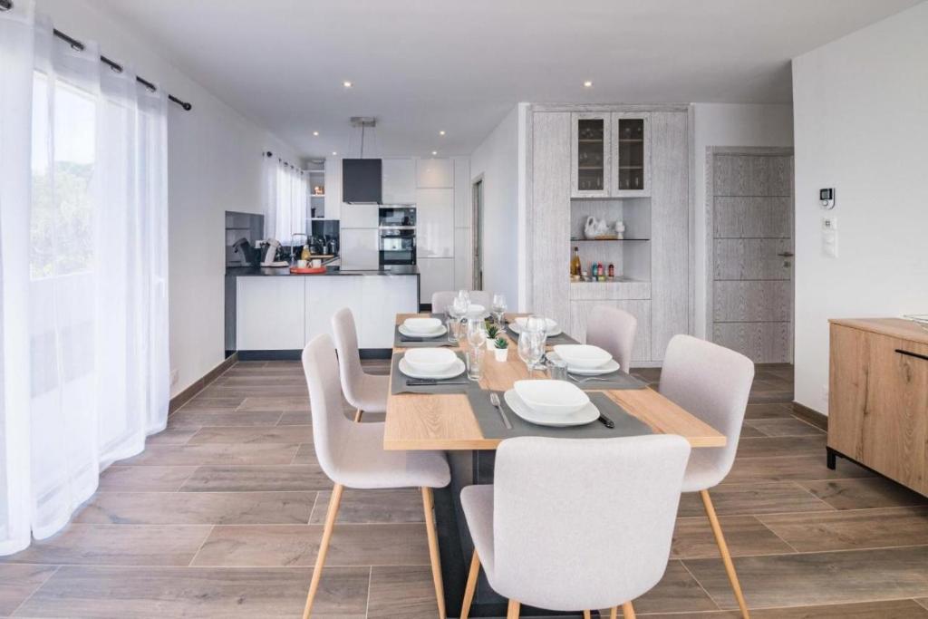 ein Esszimmer mit einem Tisch und weißen Stühlen in der Unterkunft Villa Plain-Pied Vue Mer in Lanildut