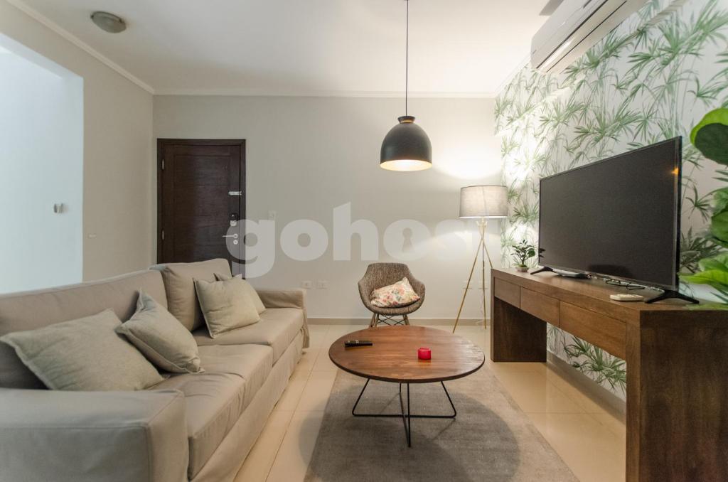 - un salon avec un canapé et une télévision dans l'établissement Amplio Dpto De 2 Dormitorios Con Parilla, à Asuncion