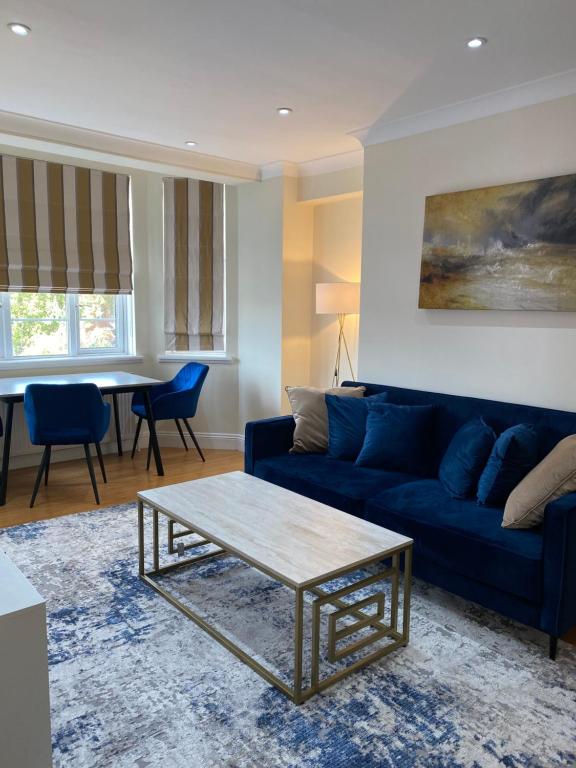 a living room with a blue couch and a table at Central London Double Bedroom by Station in London