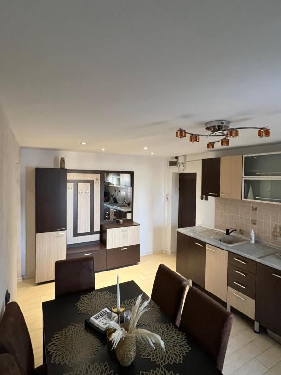 a kitchen and living room with a table and chairs at GRAY APARTAMENT in Craiova