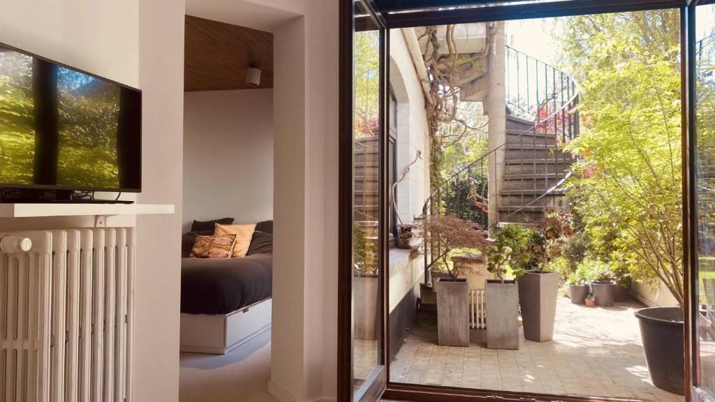 - une chambre avec une porte coulissante en verre donnant sur un balcon dans l'établissement Batpart batman appartement 1 piéce, à Bruxelles
