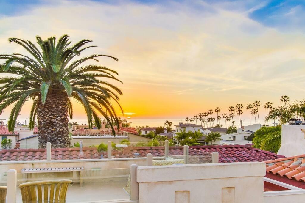 een palmboom op het dak van een huis met zonsondergang bij Large Luxury Beach House with Rooftop Views! in San Diego