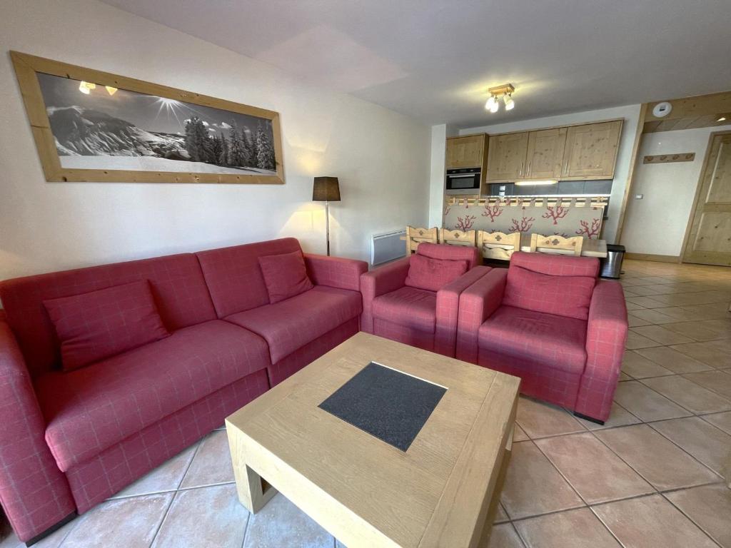 ein Wohnzimmer mit zwei roten Sofas und einem Tisch in der Unterkunft Appartement Saint-Martin-de-Belleville, 4 pièces, 6 personnes - FR-1-452-133 in Saint-Martin-de-Belleville