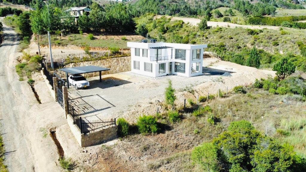 una vista aérea de una casa blanca en una colina en CASA LUCE DI CIELO, en Tinjacá