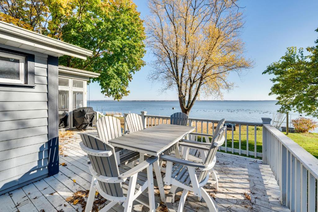 - une table et des chaises sur une terrasse avec vue sur l'eau dans l'établissement Lakefront Edgerton Cottage with Deck and Grill!, à Edgerton
