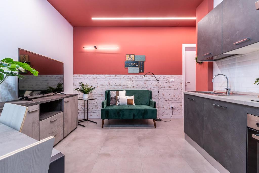 una cocina con paredes rojas y una silla verde en Tartini Lofts en Bolonia
