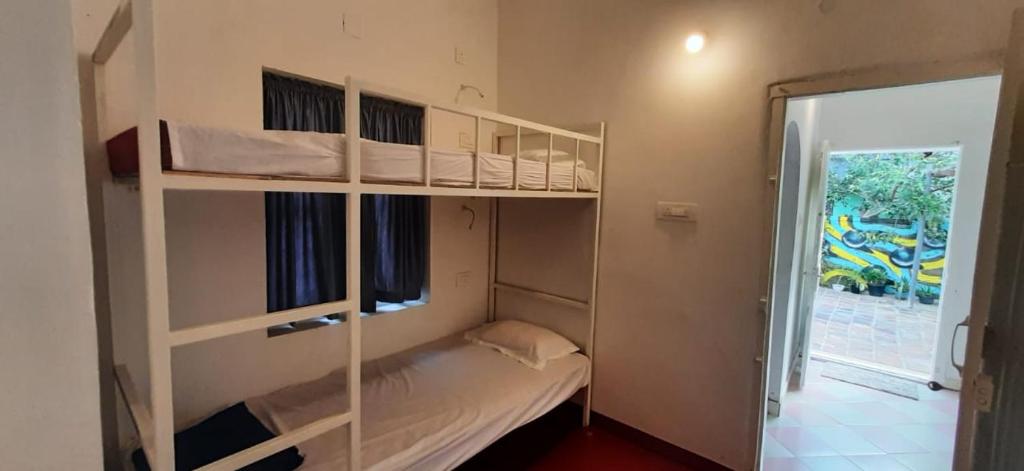 a room with two bunk beds and a window at a LoFT in Alleppey