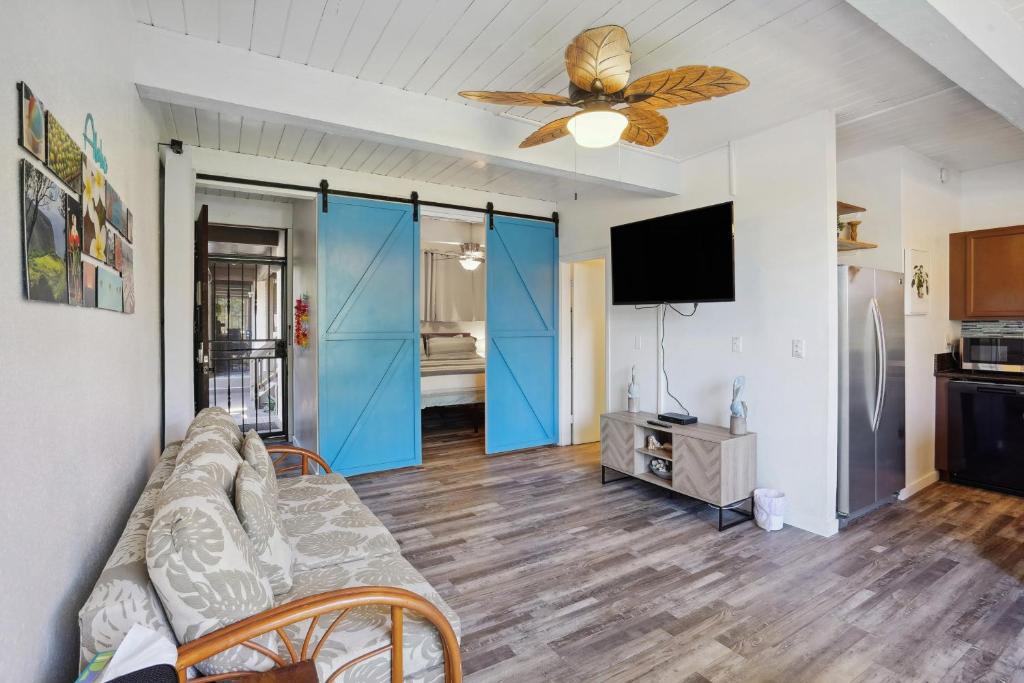 een woonkamer met een bank en een plafondventilator bij Airy Kailua-Kona Condo Less Than 1 Mi to Beach and Town in Kailua-Kona