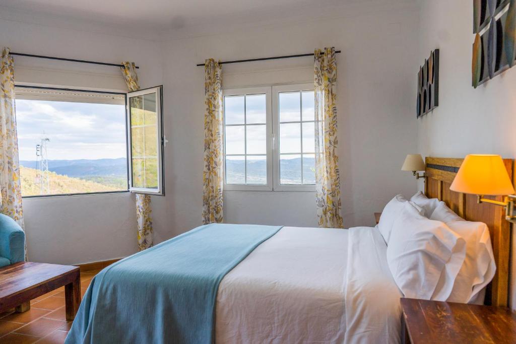 Un dormitorio con una cama y una ventana grande. en Complejo Los Veneros, en Santa Ana la Real