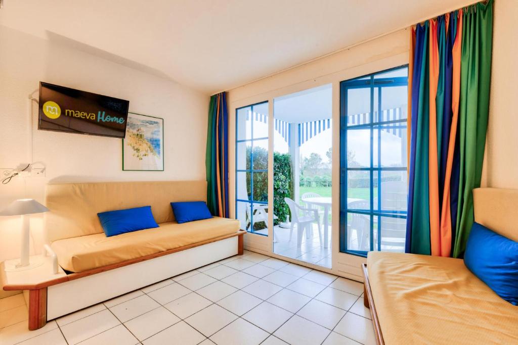 une chambre avec un lit et une grande fenêtre dans l'établissement Résidence Port Bourgenay - maeva Home - Appartement 2 Pièces 4 Personnes - Sélection MAE-2054, à Talmont-Saint-Hilaire