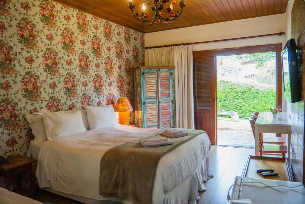 um quarto com uma cama num quarto com uma janela em Hotel Ascona em Campos do Jordão