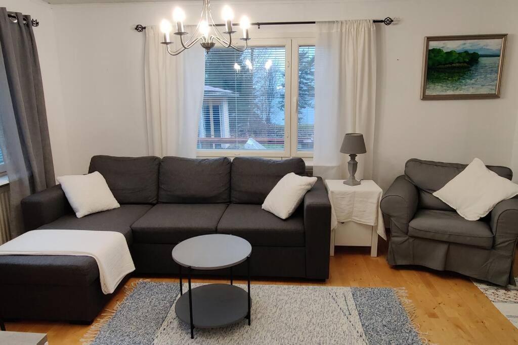 a living room with a couch and a chair at Saarijärvi - Omakotitalo, oma ranta in Kolkanlahti