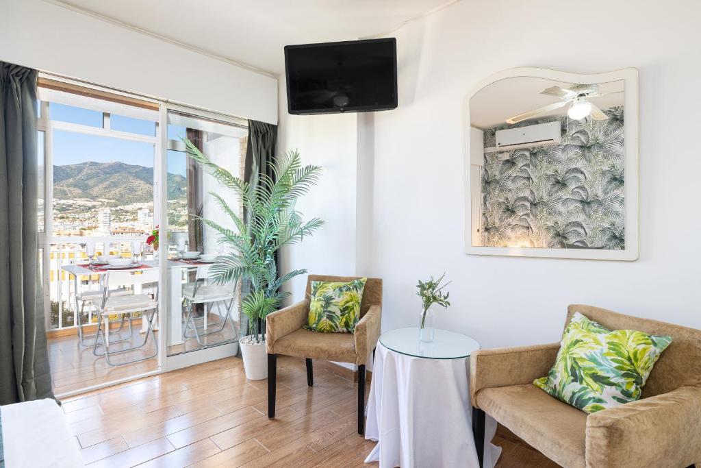 a living room with two chairs and a table at Holidays2Arroyo de la Miel - Studios with terrace and Pool 800 mts from beach in Arroyo de la Miel