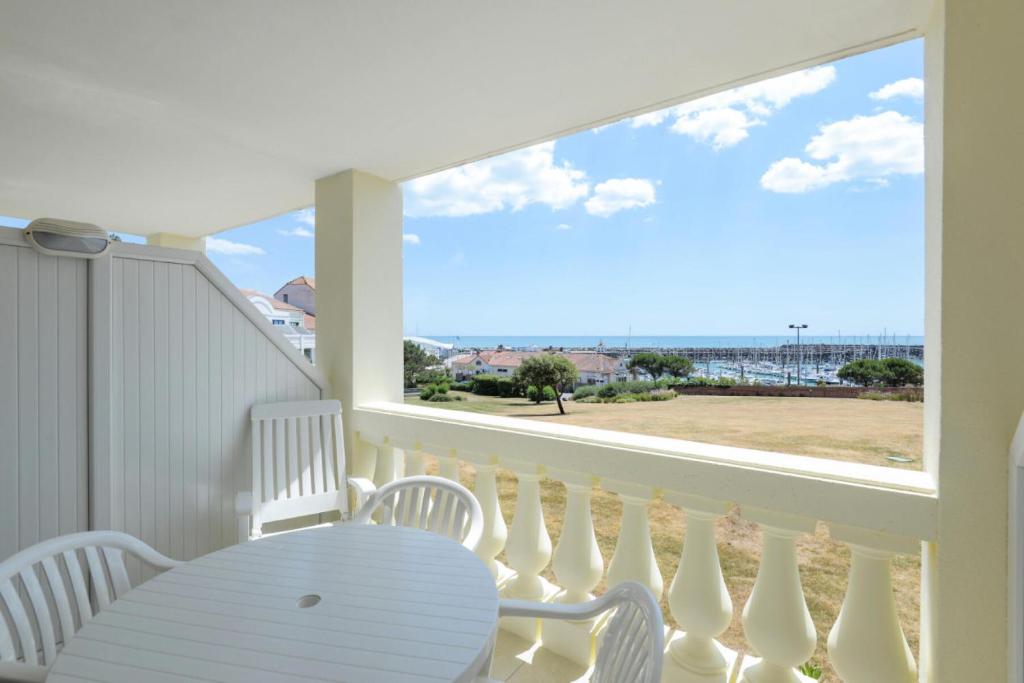 - un balcon blanc avec une table et une vue sur l'océan dans l'établissement Résidence Port Bourgenay - maeva Home - 2 Pièces 5 Personnes Sélection MAE-2059, à Talmont-Saint-Hilaire