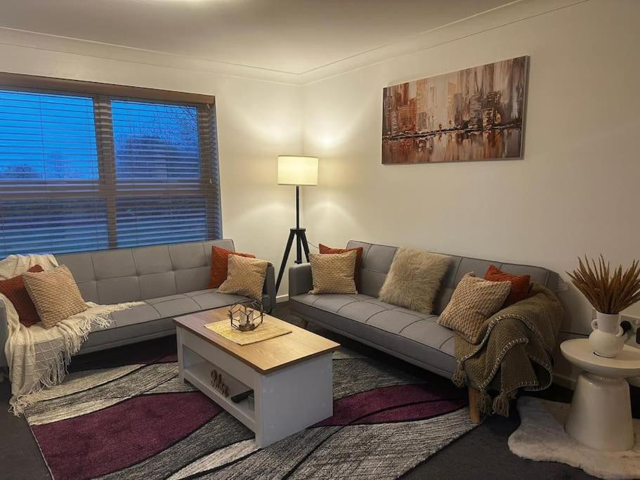 a living room with a couch and a table at Majestic Homes Heathrow - FREE PARKING in Stanwell