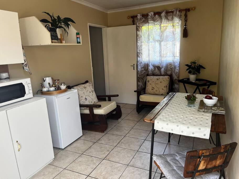 cocina y sala de estar con mesa y sillas en @Rest experience peace, en Bloemfontein
