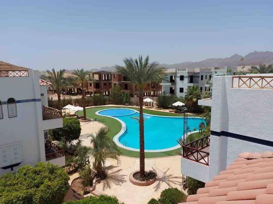 Riviera Resort Apartment - Pool view & Wifi في شرم الشيخ: اطلالة جوية على مسبح في منتجع