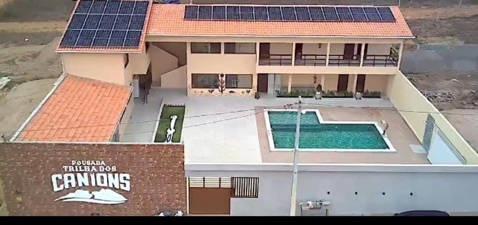 une maison avec des panneaux solaires en haut dans l'établissement Pousada Trilha dos Canions, à Olho D’Água do Casado