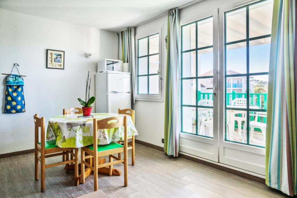 une cuisine avec une table, des chaises et un réfrigérateur dans l'établissement Résidence Port Bourgenay - maeva Home - 2 Pièces 4 Personnes Sélection MAE-3157, à Talmont-Saint-Hilaire