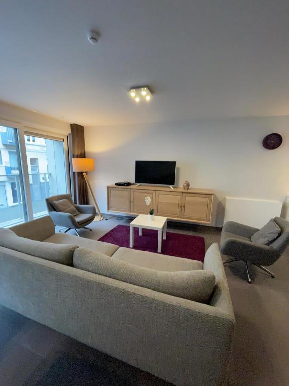 a living room with a couch and chairs and a tv at Vakantieappartement - Gratis garage - Topligging in Ostend