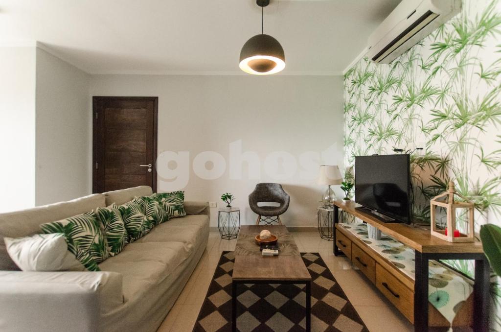 sala de estar con sofá y TV en Hampton 2 Bedrooms Balcony And Bbq, en Asunción